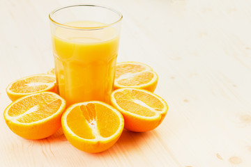 Glass of freshly pressed orange juice with sliced orange halfs