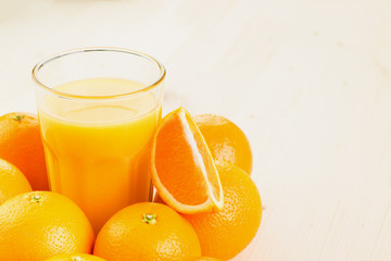 Glass of freshly pressed orange juice with oranges