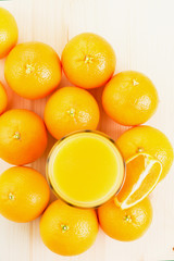 Glass of freshly pressed orange juice with oranges