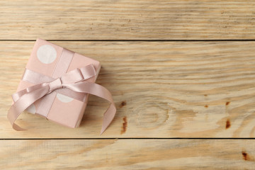 Pink gift box on natural wooden background. Valentine's Day. top view with space for text