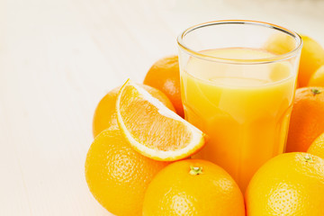 Glass of freshly pressed orange juice with oranges
