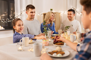 celebration, holidays and people concept - happy family having tea party at home