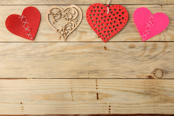 frame from different hearts on a natural wooden background. Valentine's Day. top view with space for text