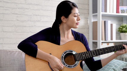 Young asian woman playing guitar