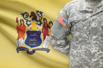 American soldier with US state flag on background - New Jersey