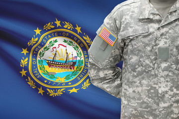 American soldier with US state flag on background - New Hampshire