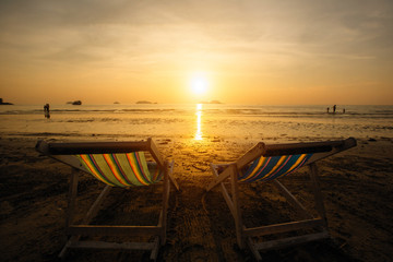Sun loungers on the sea beach during sunset.