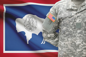 American soldier with US state flag on background - Wyoming