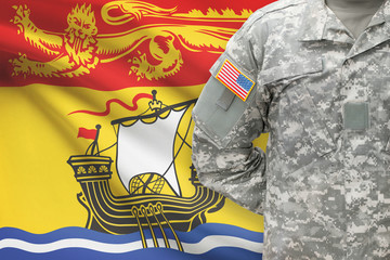 American soldier with Canadian province flag on background - New Brunswick