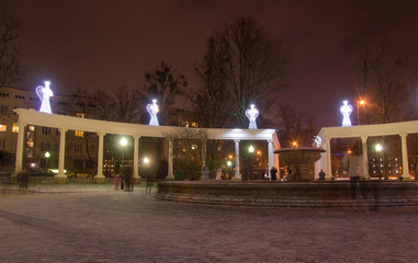 Fototapeta na wymiar Monument with LED statues of angels on a winter night