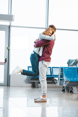 happy woman hugging boyfriend in airport