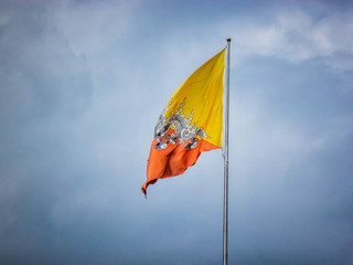 The national flag of Bhutan against a dramatic sky