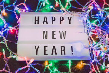 lightbox with Happy New Year message surrounded by colorful fairy lights