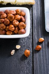 hazelnut cream sandwich breakfast and ingredients on white cutting board, black wooden table background