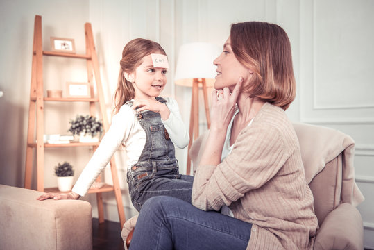 Pleasant cute girl looking at her mom