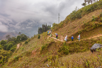 Sa pa, Vietnam-December 13, 2013. Black Hmong women walking with tourists on the way to Muong Hoa...