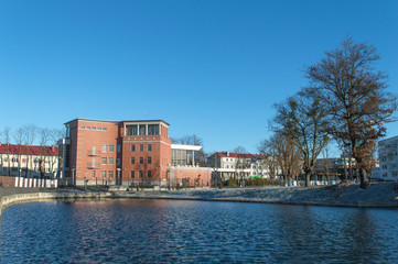 Naklejka premium Winter day landscape by the lake with trees on a sunny and snowy day