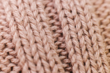 Texture of knitted woolen brown fabric for wallpaper and an abstract background. Soft focus