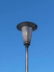 Dirty street lamp against the blue sky in the afternoon