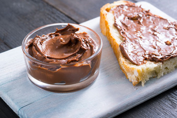 hazelnut cream sandwich breakfast and ingredients on white cutting board, black wooden table background