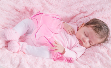 Fototapeta na wymiar Baby girl asleep on pink bed. Newborn. Pink clothes.