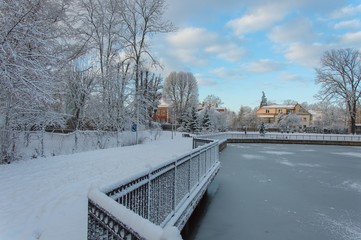 Naklejka na ściany i meble Winter landscape on the lake shore on a sunny day with snow and blue sky
