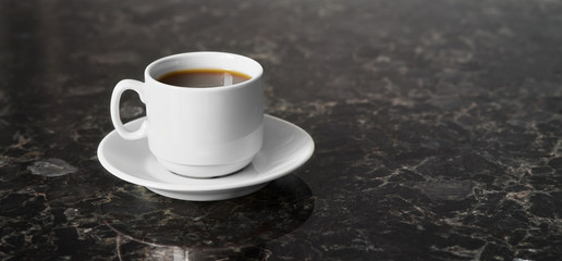 White cup of esoresso on granite table surface, copy space