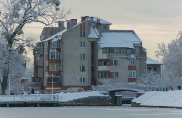 Obraz premium Winter day landscape by the lake with trees on a sunny and snowy day