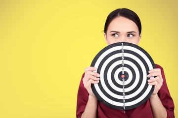 Beautiful businesswoman portrait holding round target of darts