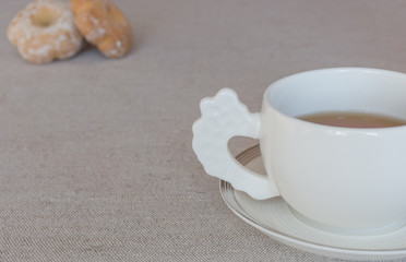 Morning tea - white cup of tea with plate and snacks. Copy space