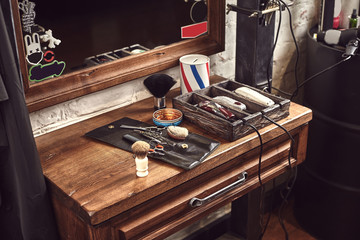 Barbershop tools on wooden brown table. Accessories for shaving and haircuts on the table.