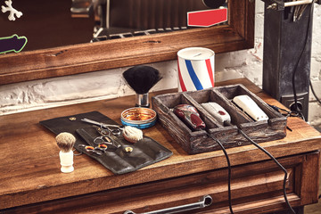 Barbershop tools on wooden brown table. Accessories for shaving and haircuts on the table.