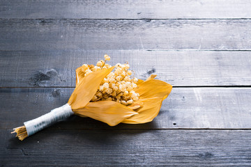 dried lily of the valley flowers on black wood table background