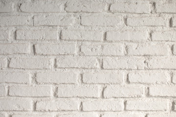 Wall is made from bricks and painted with white color.