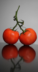 Two red ripe tomatoes lying on the table
