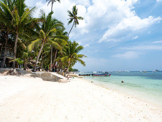 Beautiful tropical beach background from Alona Beach at Panglao Bohol island, the white sand beach with cloudy blue sky and palm trees. Travel Vacation, Philipines, november, 2018