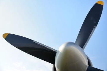Retro plane with propellers on blue sky background. Airplane details with clouds. Aviation...