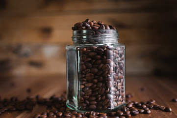 Close-up of coffee beans in a glass jar on wooden background