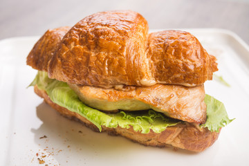 Closeup of tasty croissant with meat and cheese