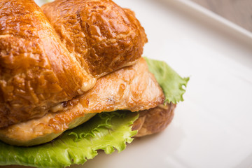 Closeup of tasty croissant with meat and cheese