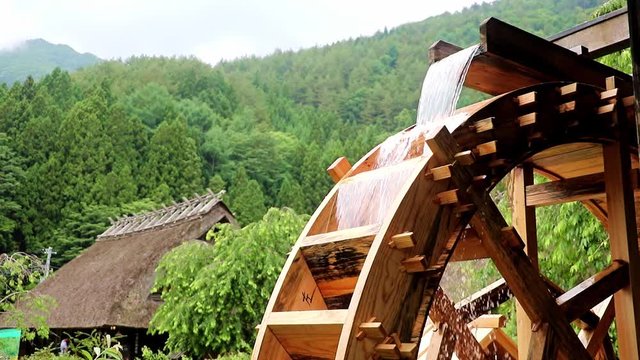 The mill wheel rotates under a stream of water 