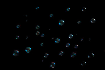 Rainbow soap bubbles on a black background.
