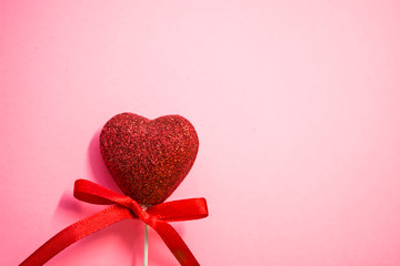 Texture. Pink background. One red heart with spangles and a bow. Tape. St. Valentine's Day. Blank space of day of an inscription.