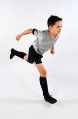 Male child soccer player running with strength and aggression