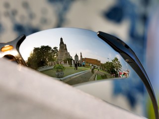 The reflection on a traveller's sunglasses at Wat Arun, Bangkok, Thailand
