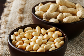 Peanuts in the shell and peeled closeup in a cup