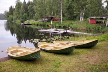 Naklejka na ściany i meble Boats on the bank of the forest lake. Finland