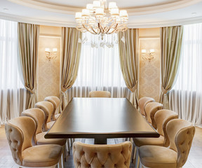 Classic interior of dining room in brown, white, beige colors, with crystal chandelier in the...