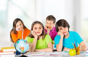 Fototapeta premium Happy children sitting by the table during lesson