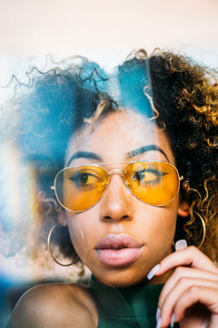Portrait of fashionable young woman wearing yellow sunglasses